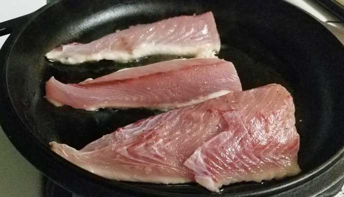 Cooking bonito fish in a pan