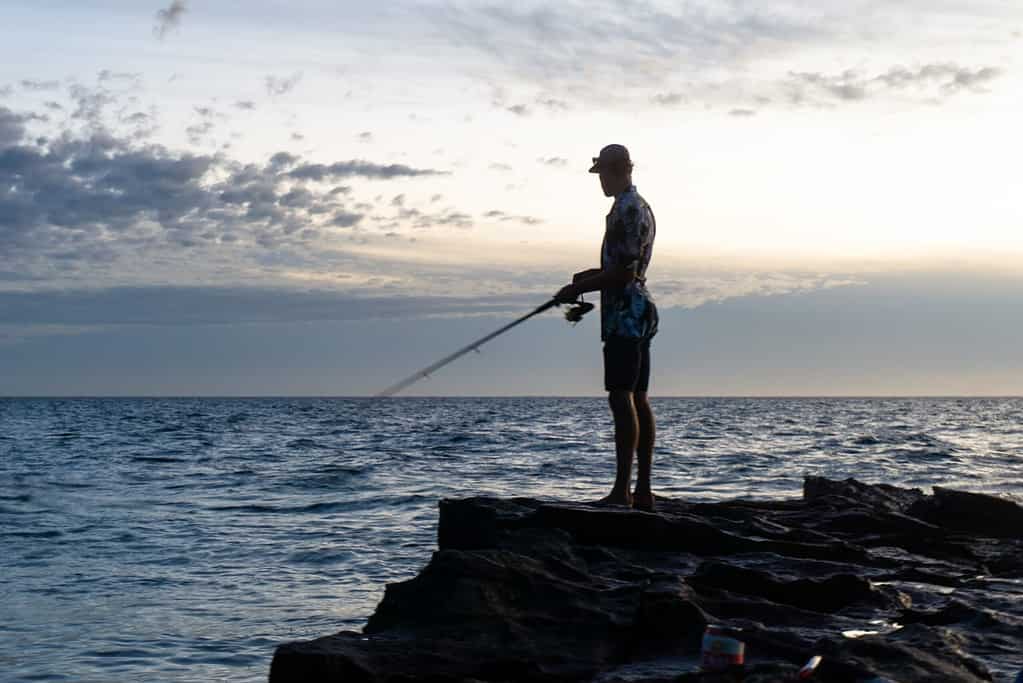 man fishing from a cliff