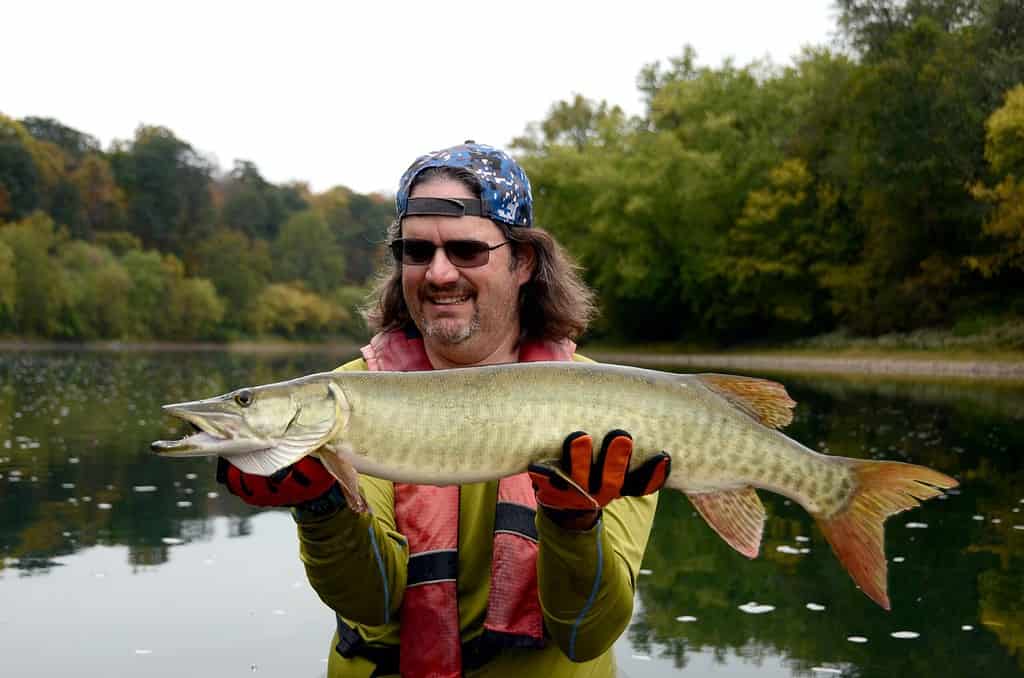 man holding a muskellunge