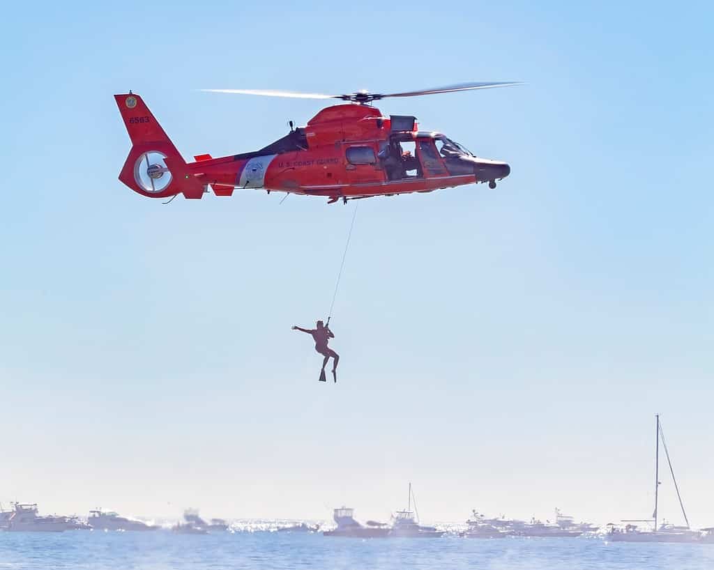 coast guard helicopter with person hanging