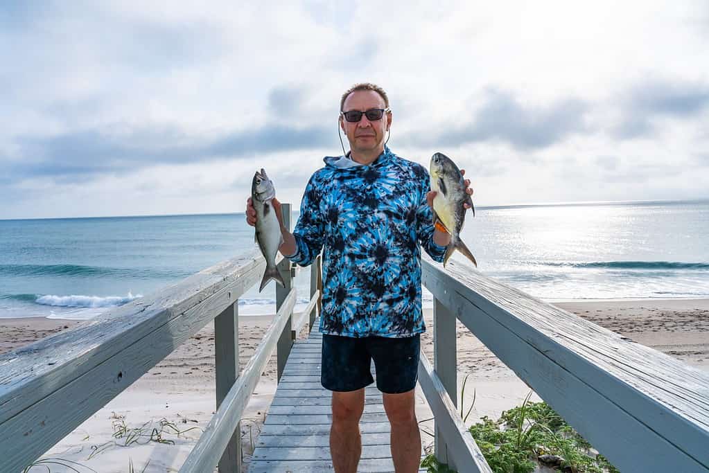 Man holding a bluefish and pompano